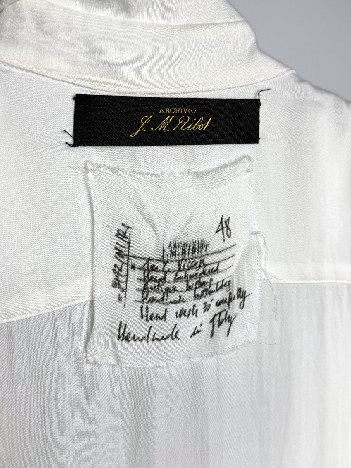 Maker's label, inked by hand: hand embroidered, antique buttons, handmade buttonholes, handmade in Italy, 48
