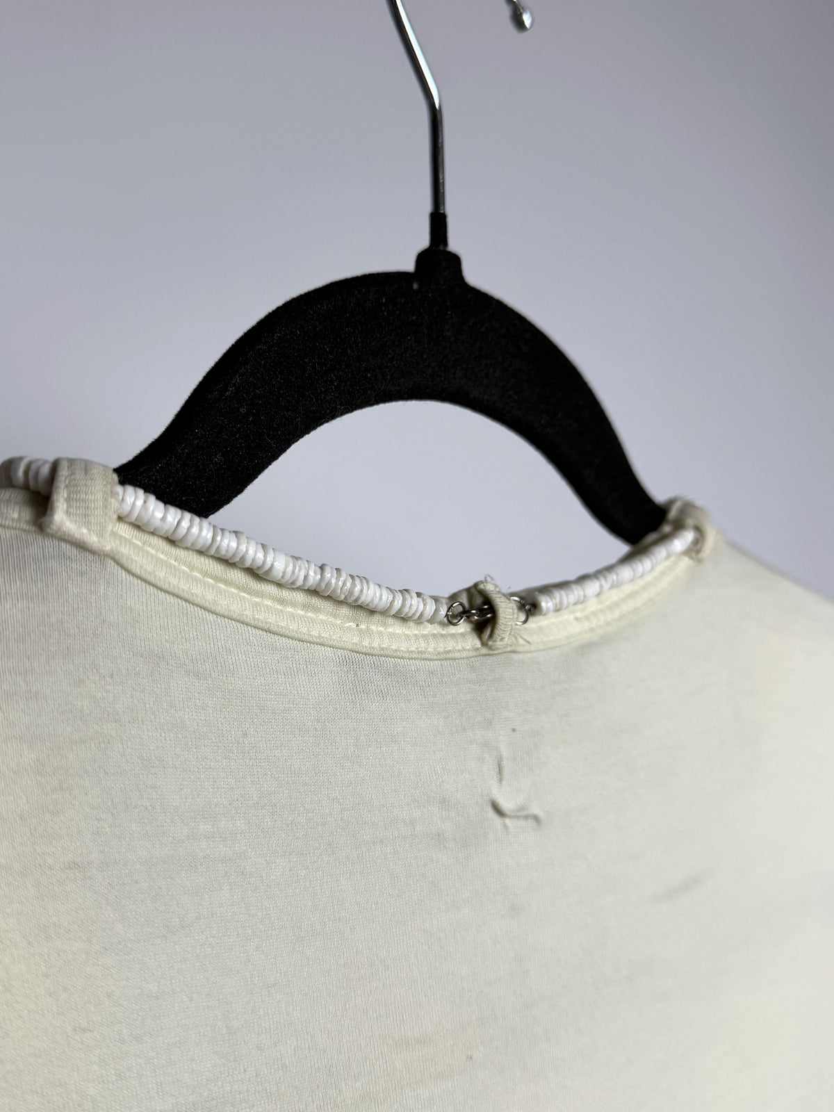 Back neckline, necklace threaded through the loops on its clasp