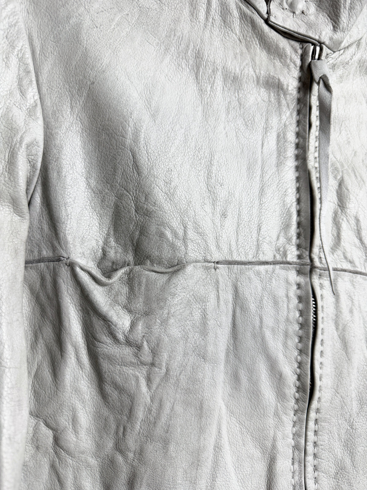 Hand stitching either side of the front zip, and the chest seam