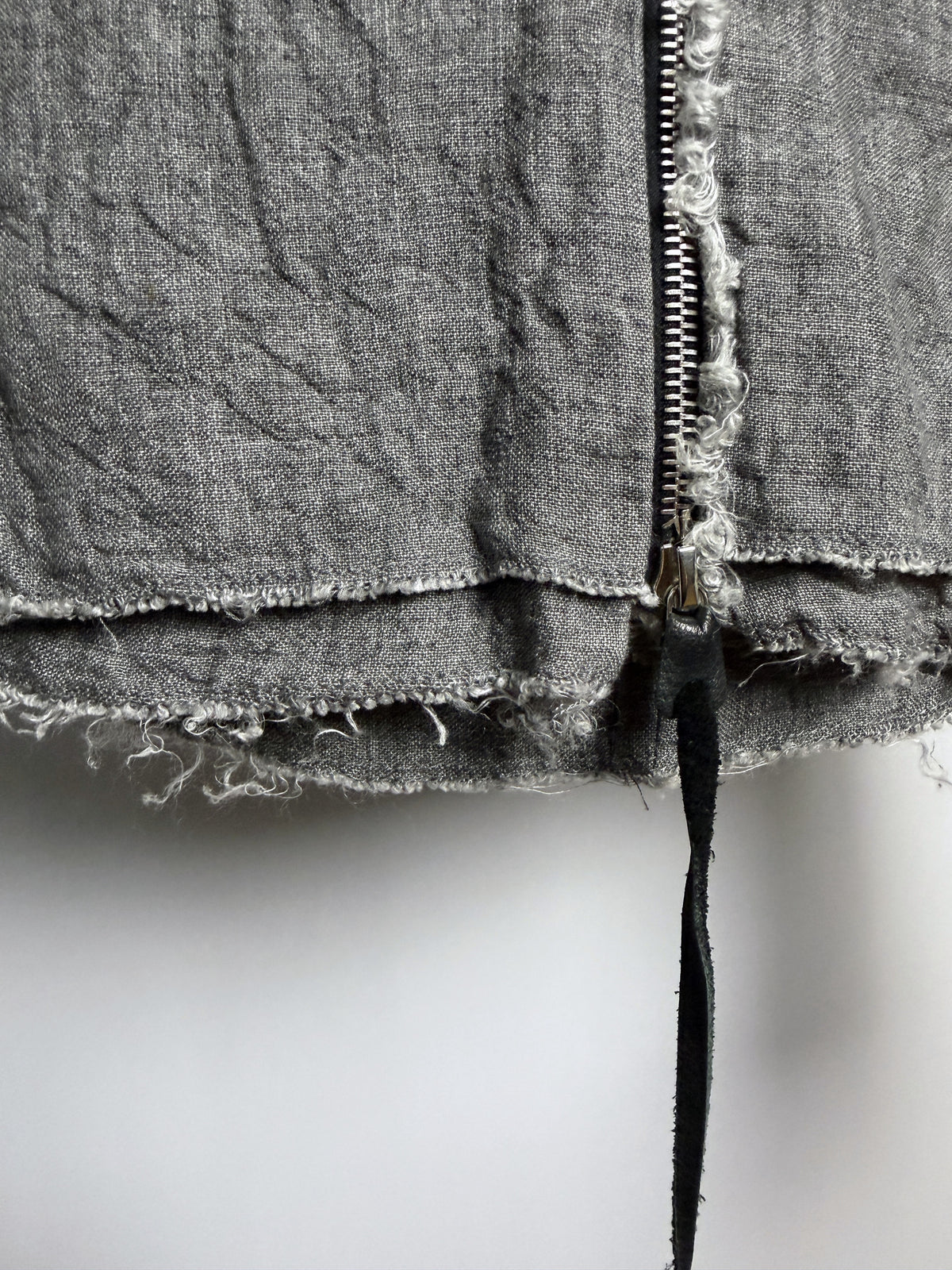 Frayed layered hem at the zip end