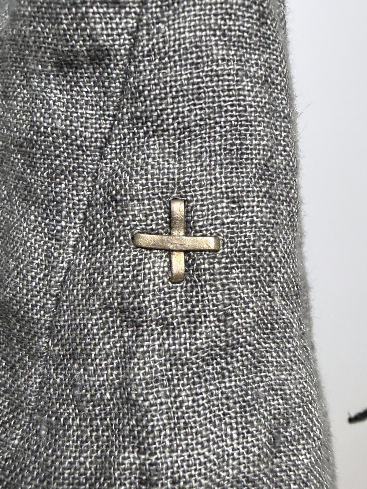 Hand-forged metal cross at the cuff, the maker's mark